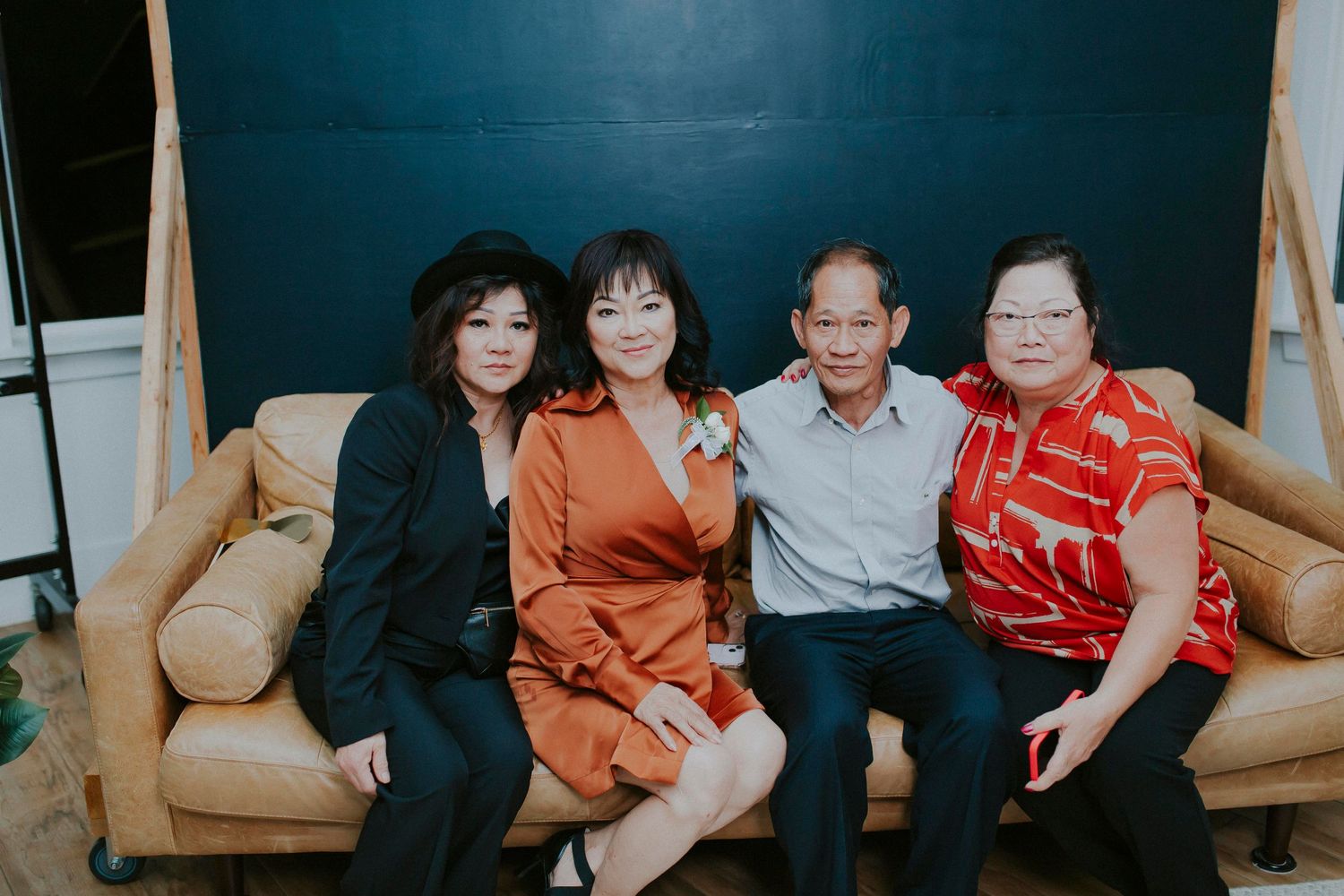 Group portrait session with coordinated outfits in front of dark blue wall.