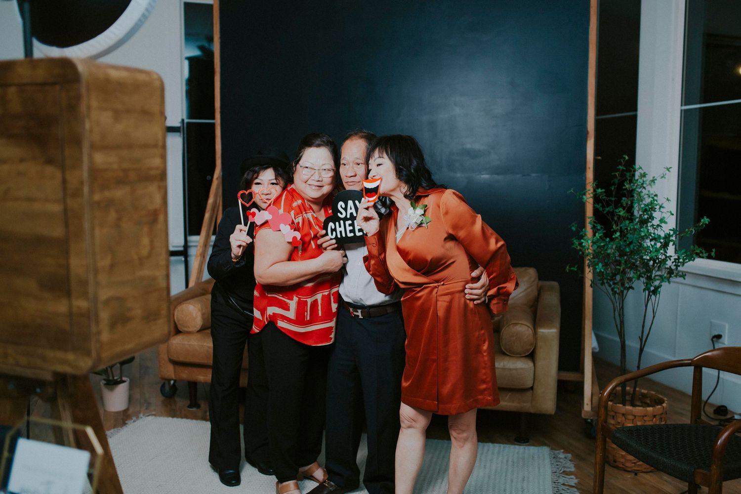 Family photoshoot featuring casual poses and bright red outfits against navy backdrop.