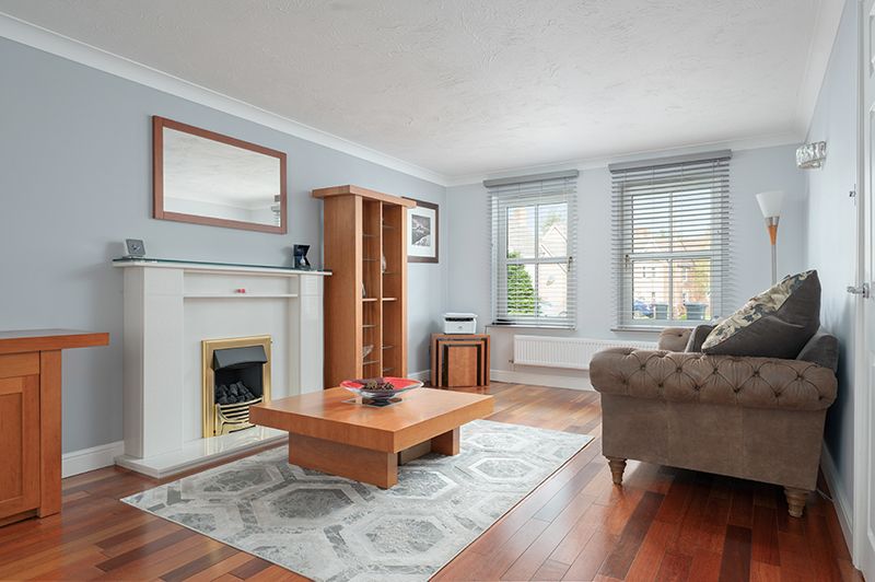 A bright living room with wooden furniture and oak flooring. Soft furnishings and modern finishes.