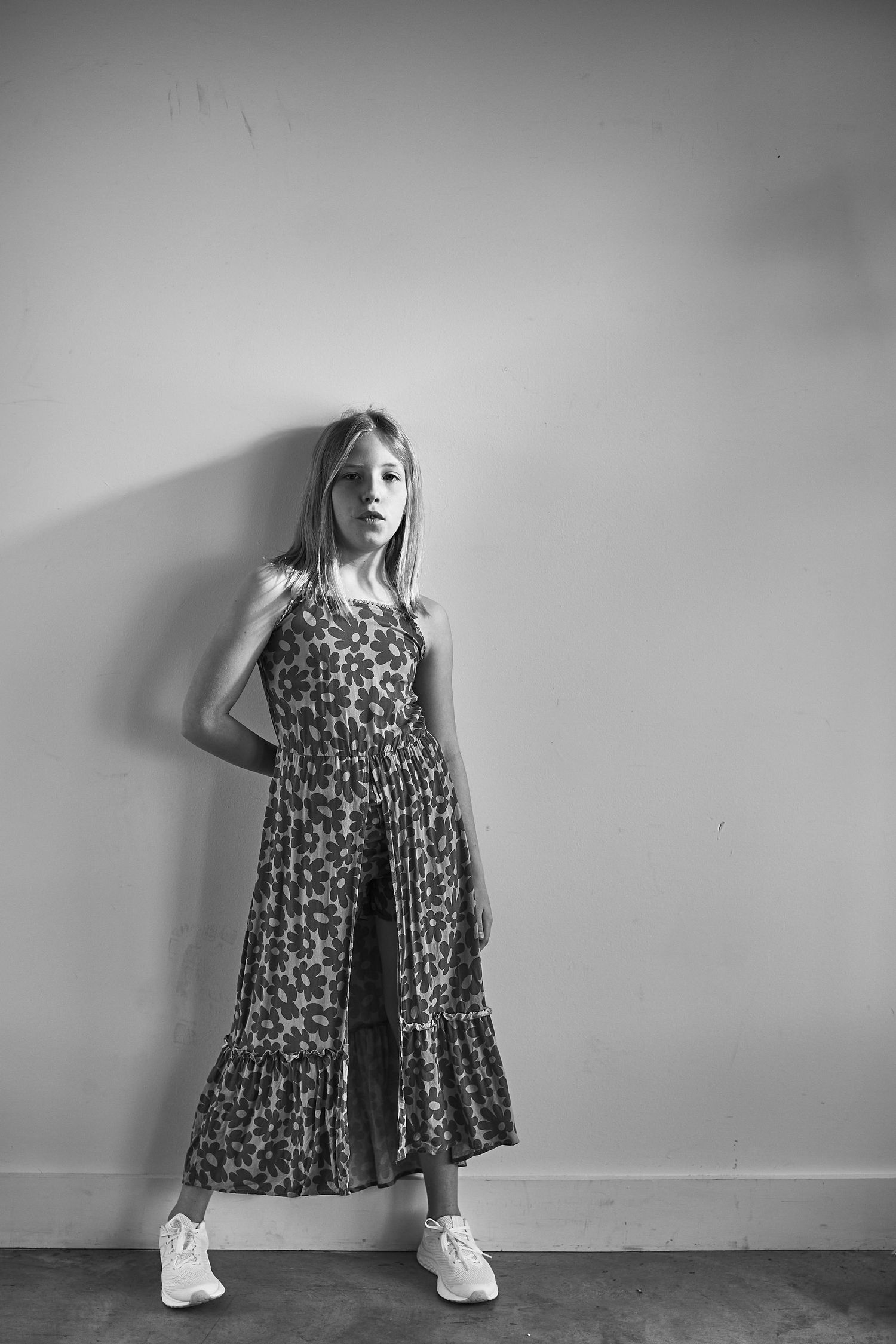 Black and white portraits of young person in patterned dress showing playful poses.