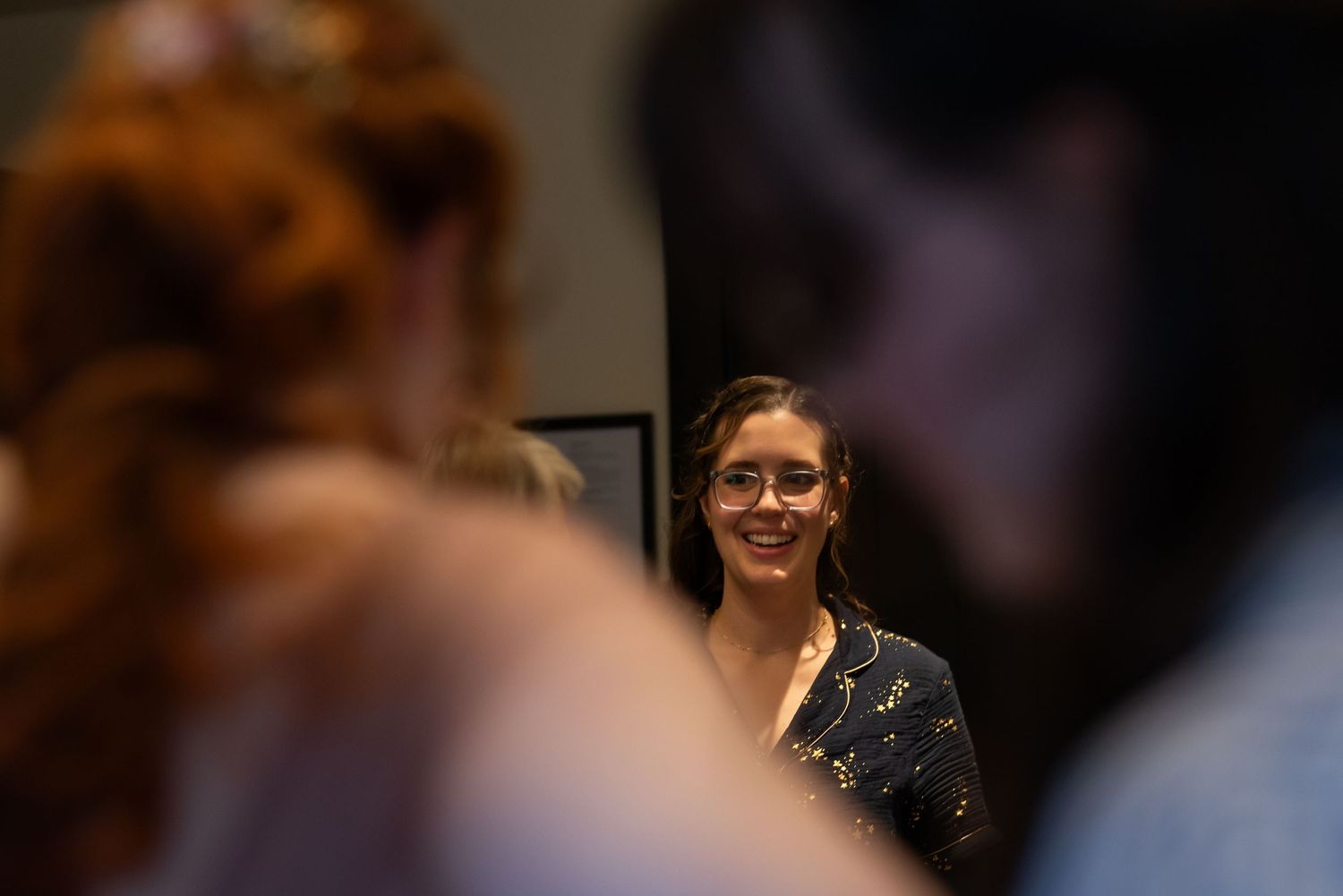 Wedding party members laugh and celebrate during an indoor reception.