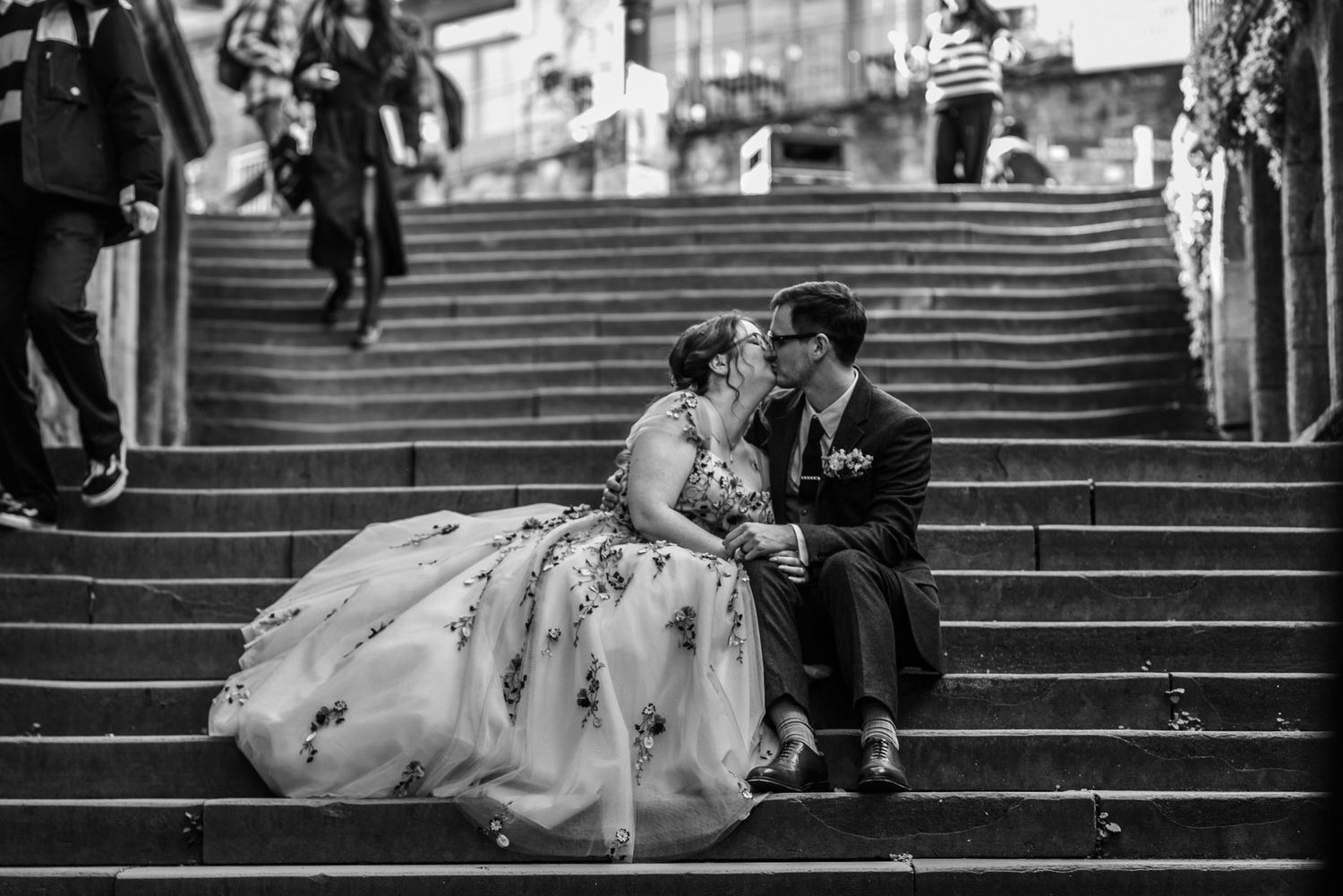 Wedding couple descending stone stairs in black and white photography.