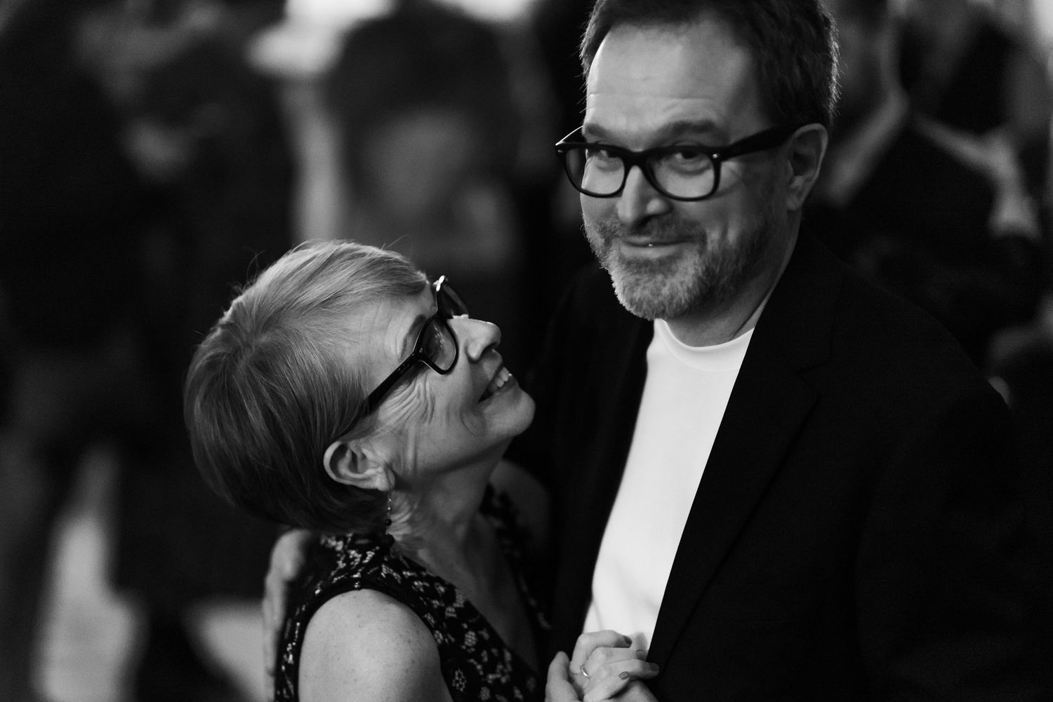 Wedding guests share joyful moments during an indoor celebration.