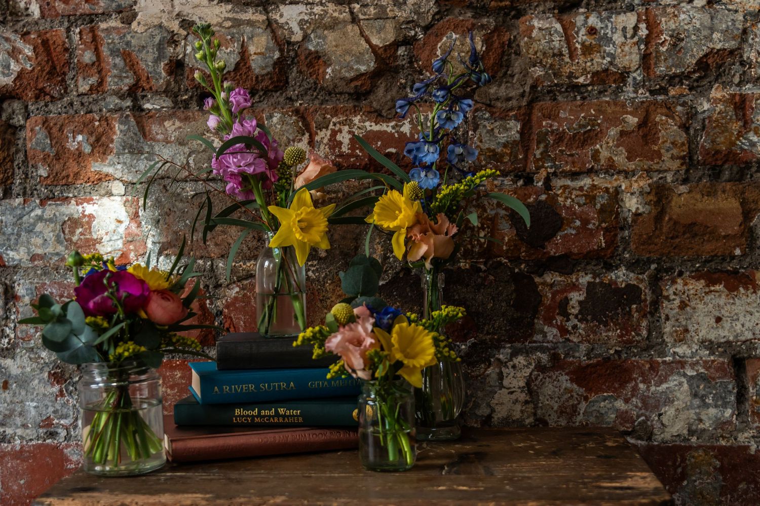 Rustic wedding venue decorated with wildflower arrangements and exposed brick walls.