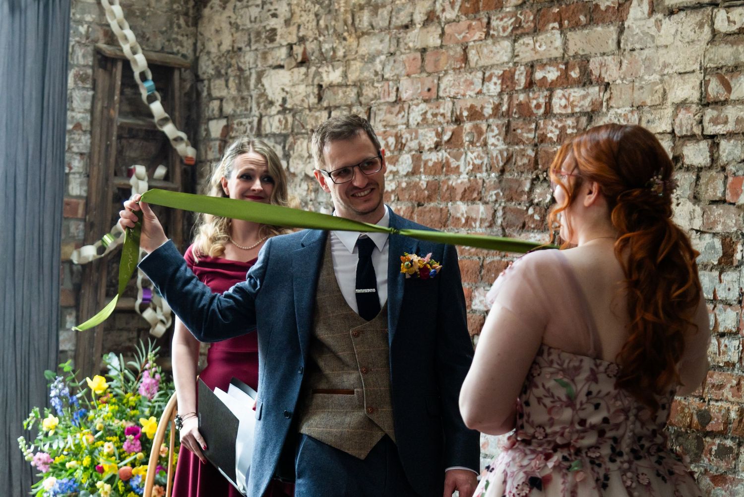 Wedding celebration in an industrial venue with exposed brick walls and floral decor.