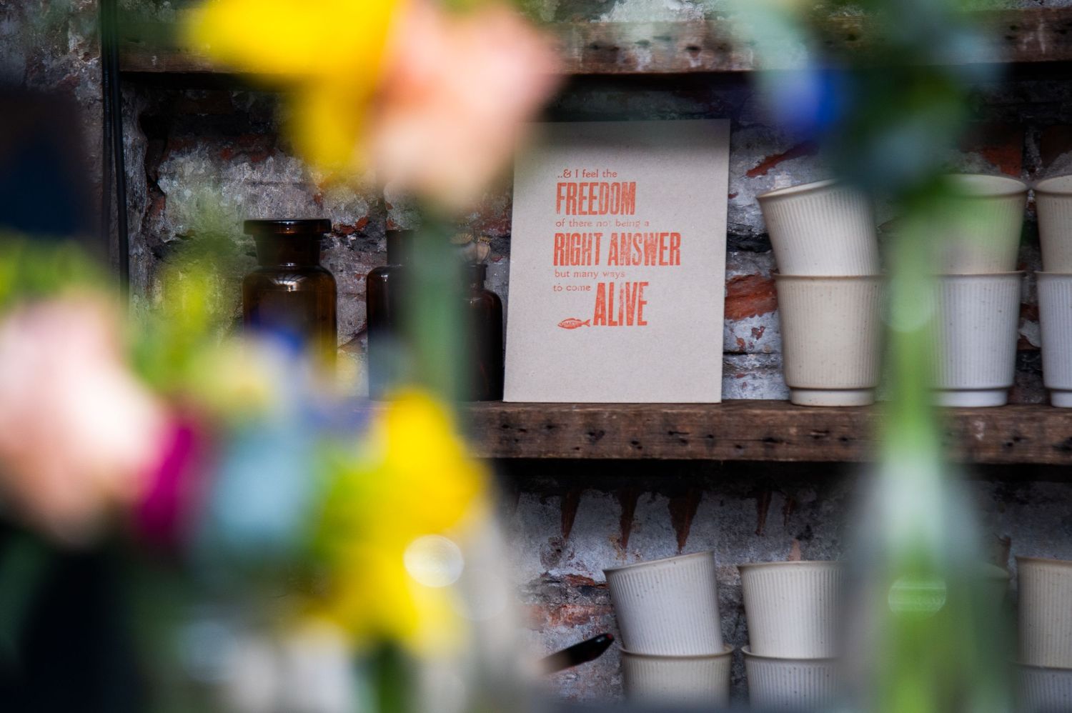 Blurred floral decorations with signs visible in the background.