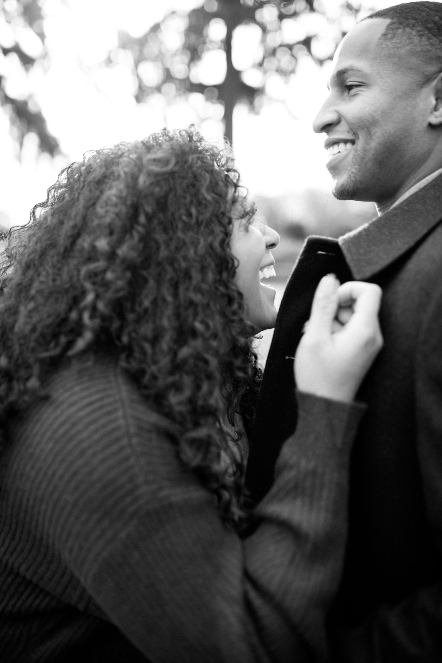Black and white portrait of a couple sharing an intimate moment outdoors.