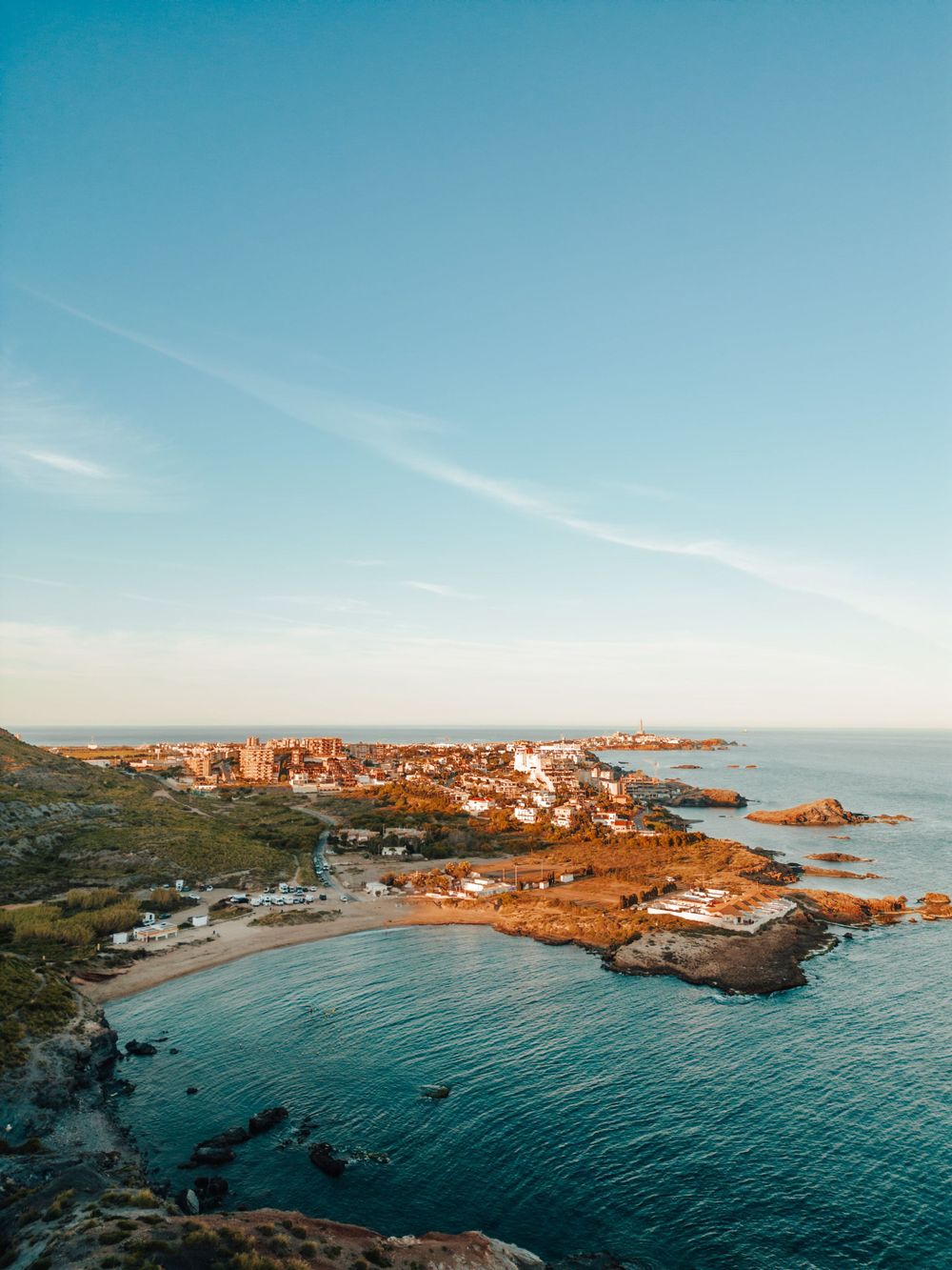 Stunning coastal town nestled along rocky Mediterranean shoreline with turquoise waters.