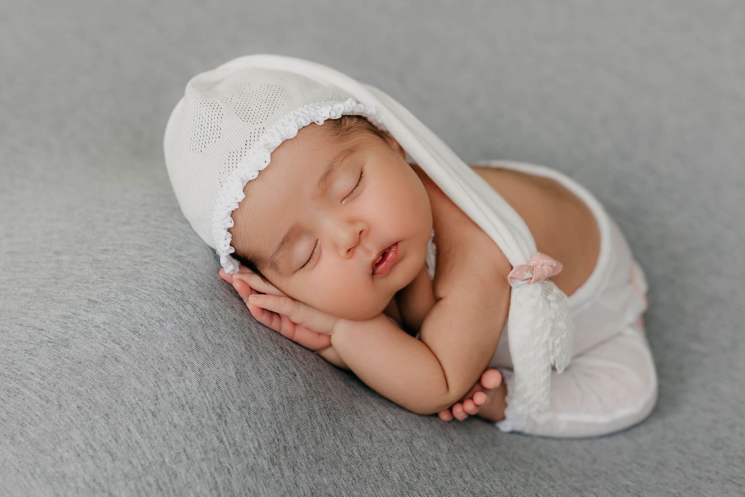 Bebé recién nacido durmiendo en una manta suave en una sesión fotográfica profesional.