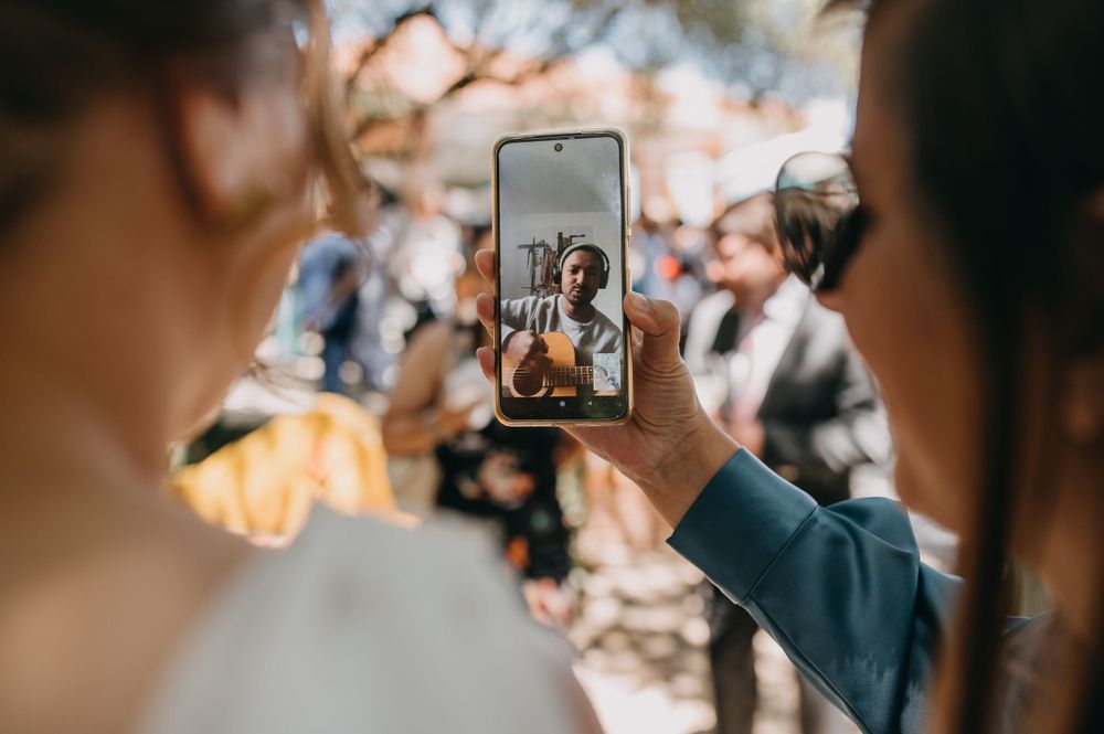 Smartphone capturing wedding moment through camera lens.