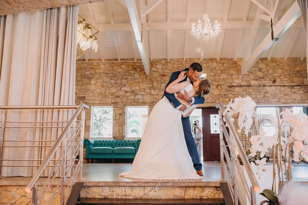 Romantic moment on rustic venue staircase with exposed brick walls.