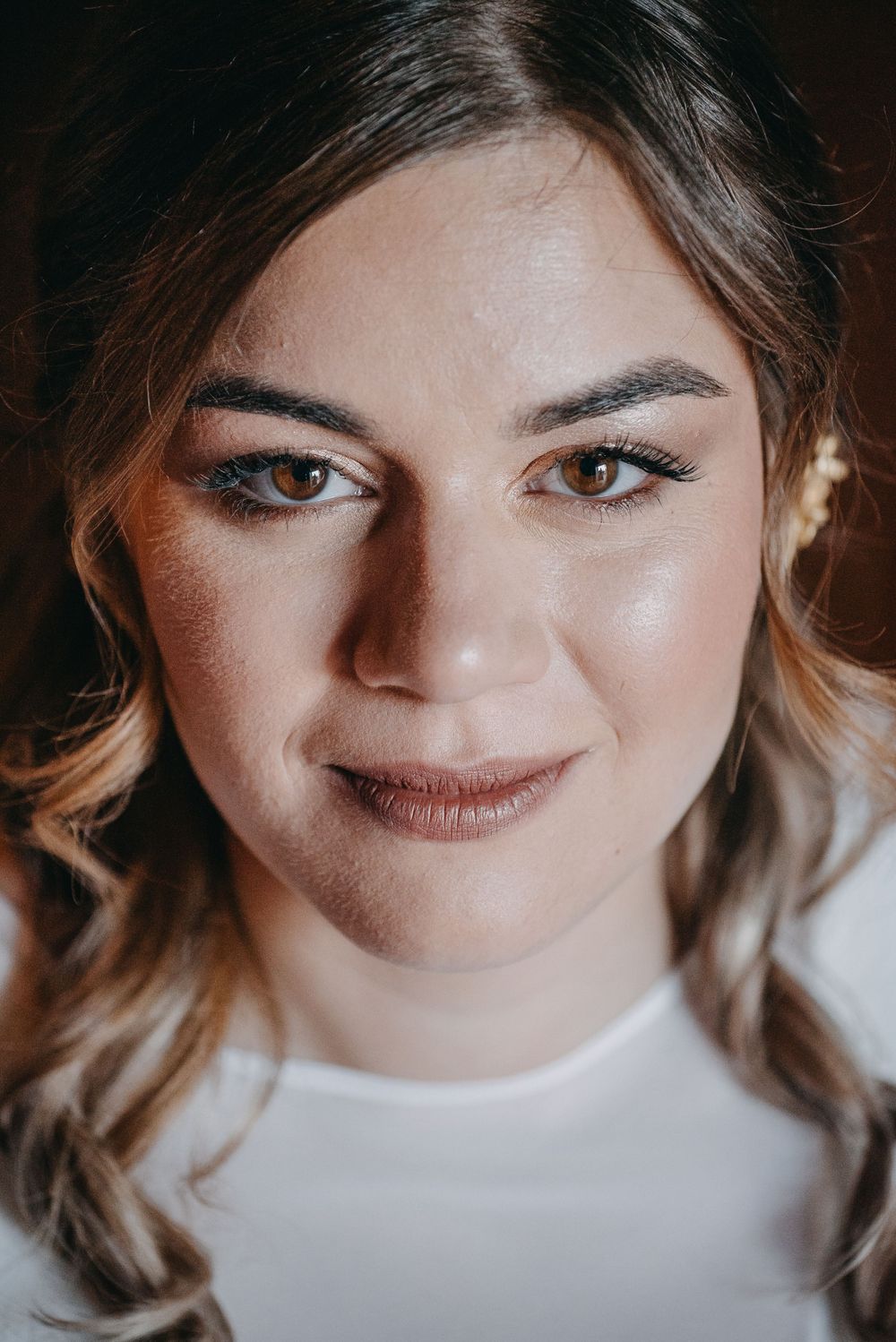 Close up beauty portrait showing soft makeup and styled hair.