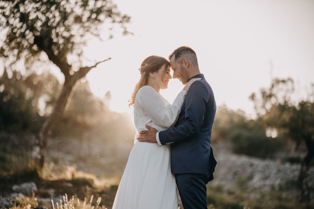 A romantic sunset moment between a couple in wedding attire.