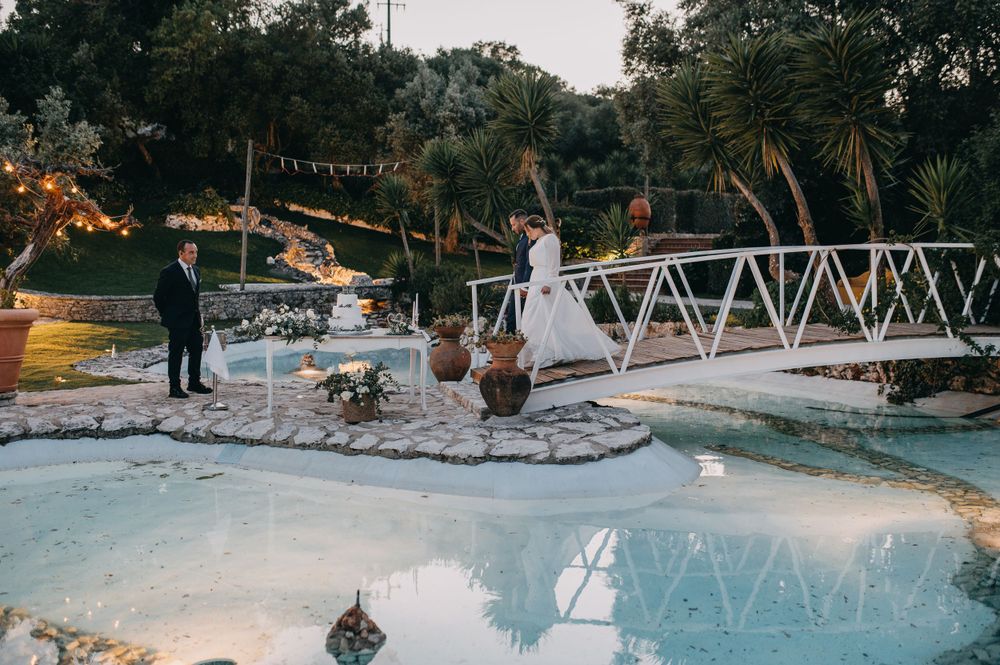 Evening wedding celebration scene with string lights over a pool area.