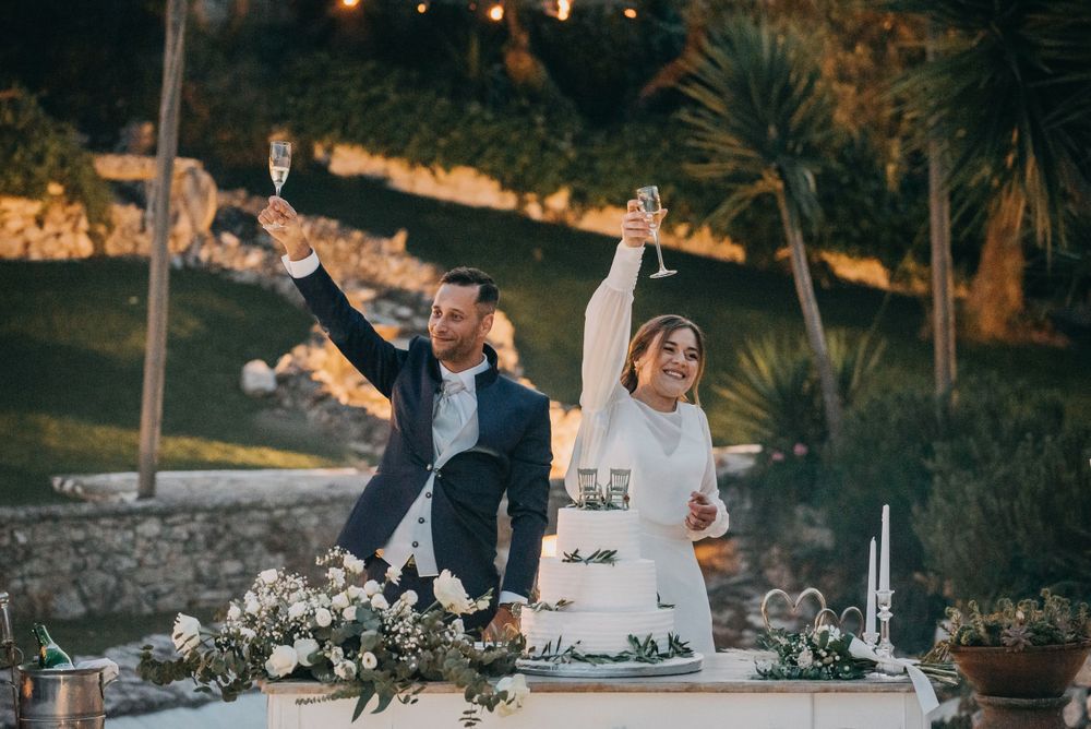 Celebratory moment at an outdoor wedding reception with floral decorations.