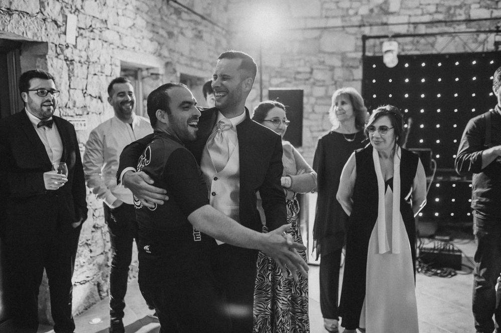 Party guests mingle and celebrate in a rustic venue with exposed brick walls.