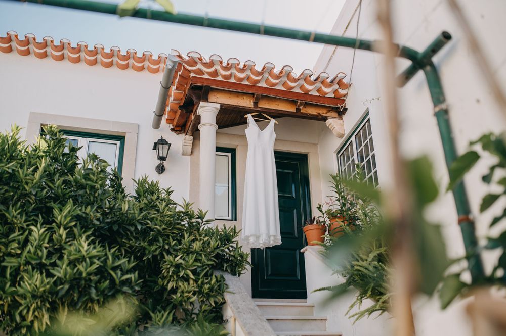 Mediterranean style entrance with a green front door, white walls, and lush greenery decorating the exterior.