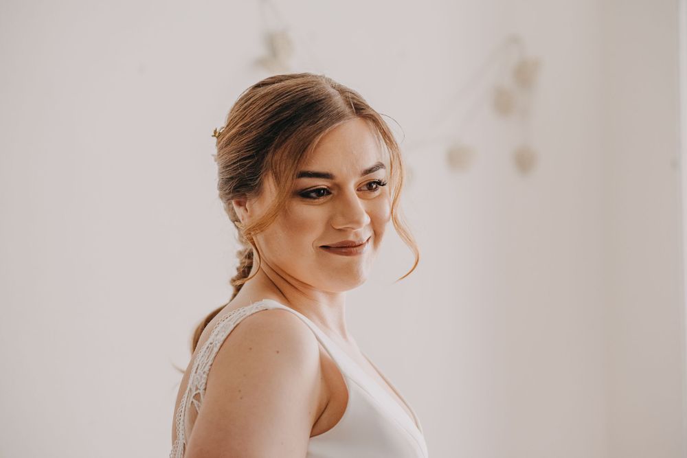 Close-up portrait shot of a wedding dress fitting session in natural light.