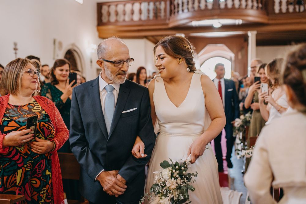 Wedding celebration in an elegant church hall with wooden balcony details.