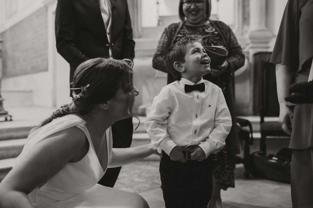 A black and white candid moment showing a child in a bowtie during a formal event.