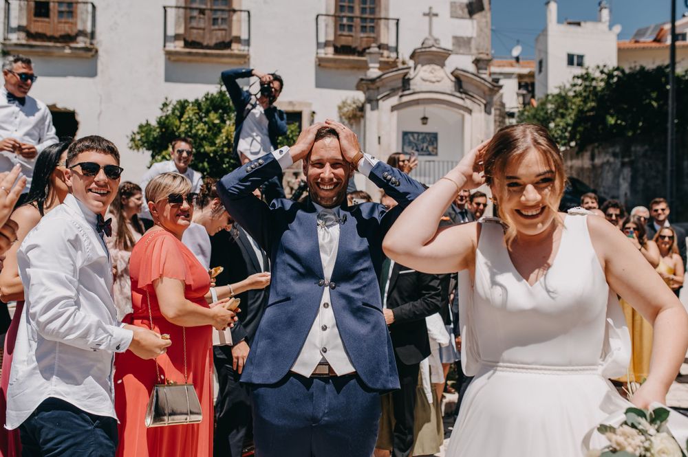 Wedding guests celebrating outdoors with joyful expressions and raised arms.