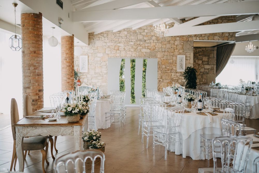 Elegant wedding reception venue with exposed brick walls and white chairs.