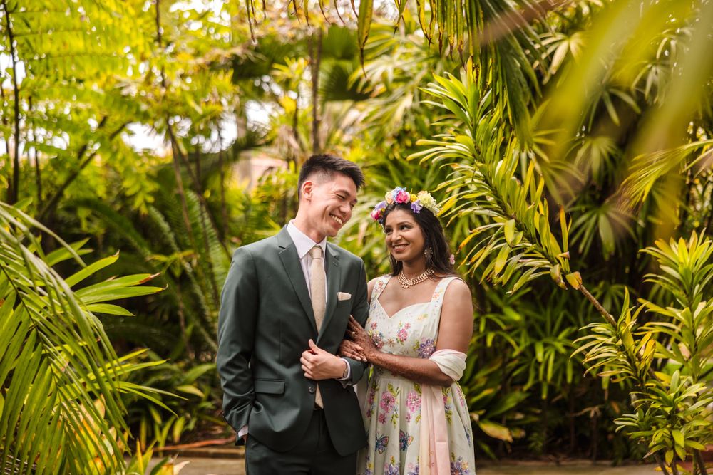 A joyful couple sharing a moment in a tropical garden setting.