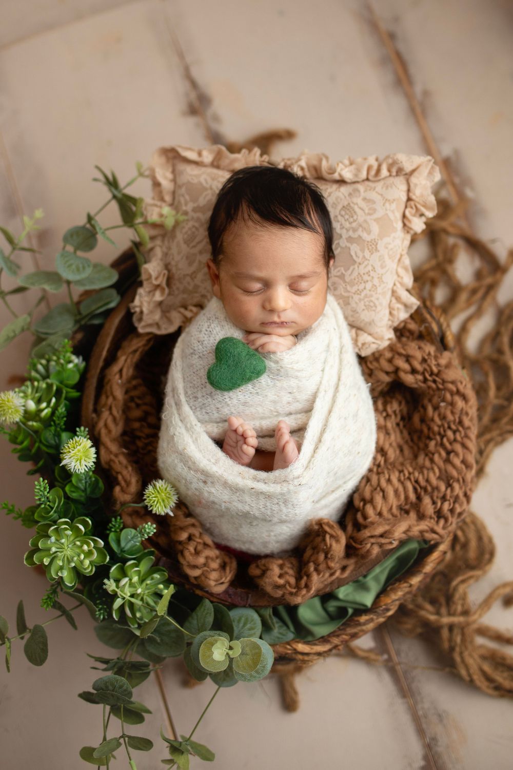 "Newborn baby peacefully sleeping on a soft, floral blanket in a cozy studio setup by a  photographer in Doha, Qatar