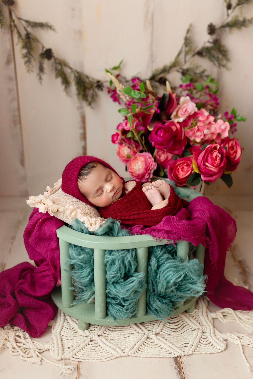 "Newborn baby peacefully sleeping on a soft, floral blanket in a cozy studio setup by a  photographer in Doha, Qatar