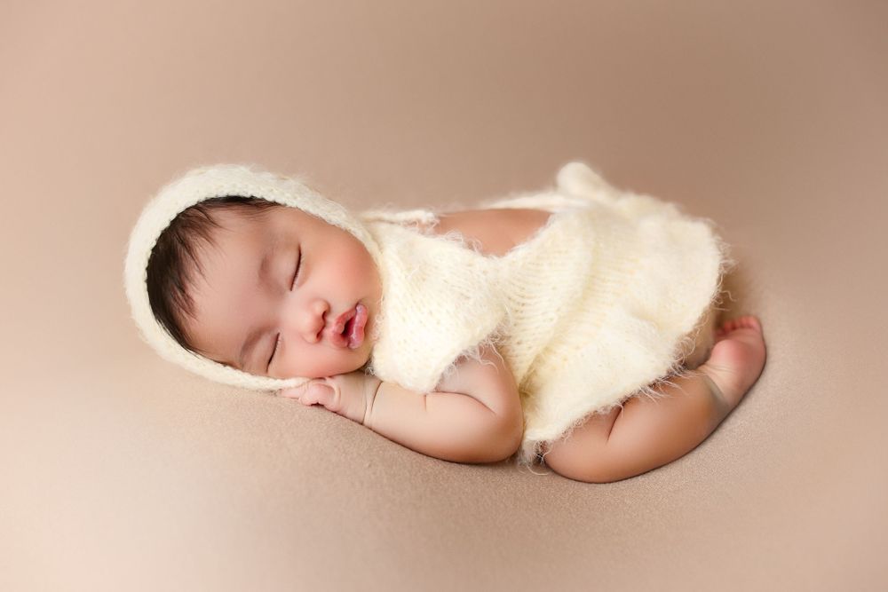 "Adorable newborn baby swaddled in prop peacefully sleeping. captured by a female photographer in Doha, qatar