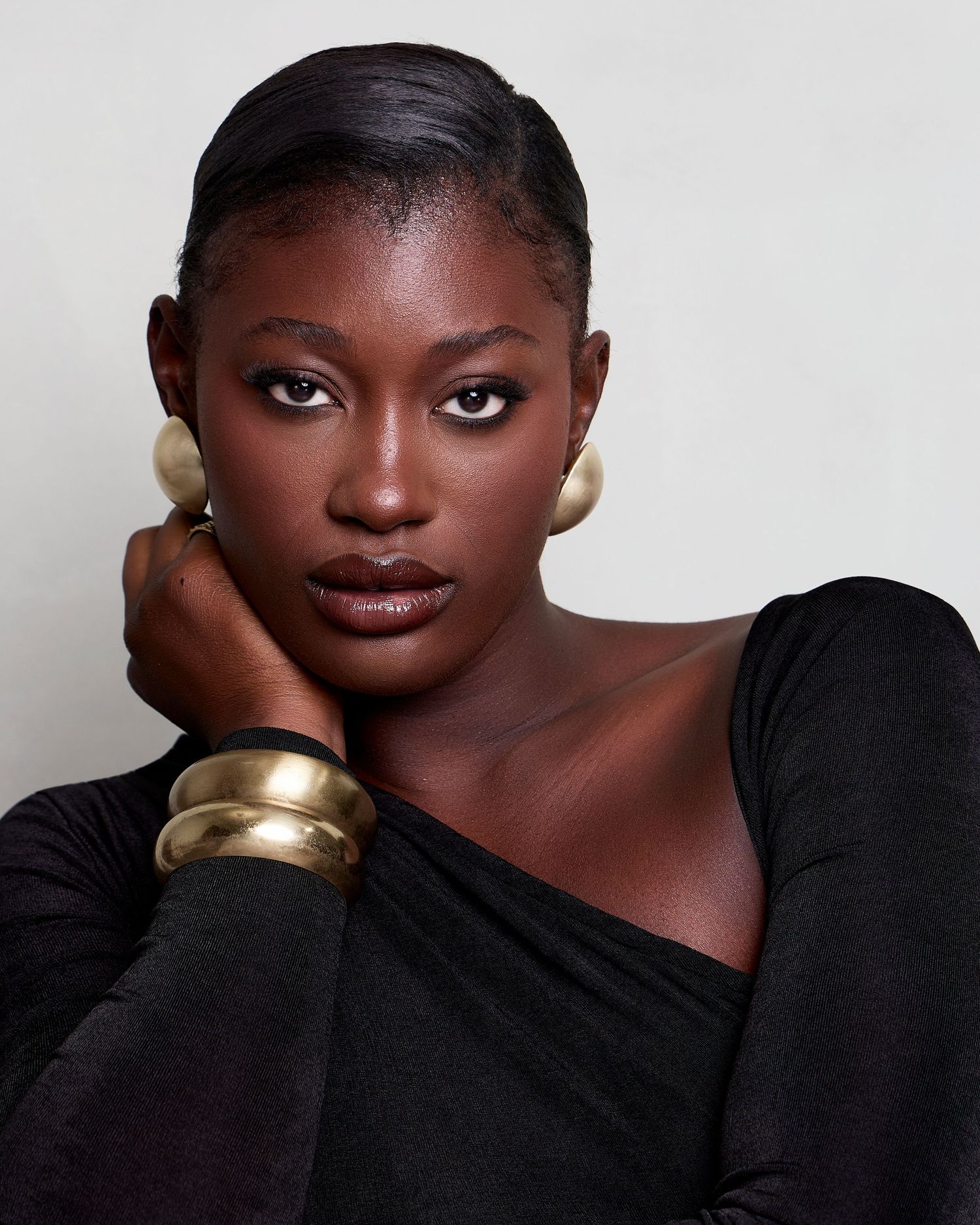 Beautiful photo series featuring five expressive profile shots of a model wearing gold accessories against white backdrop.
