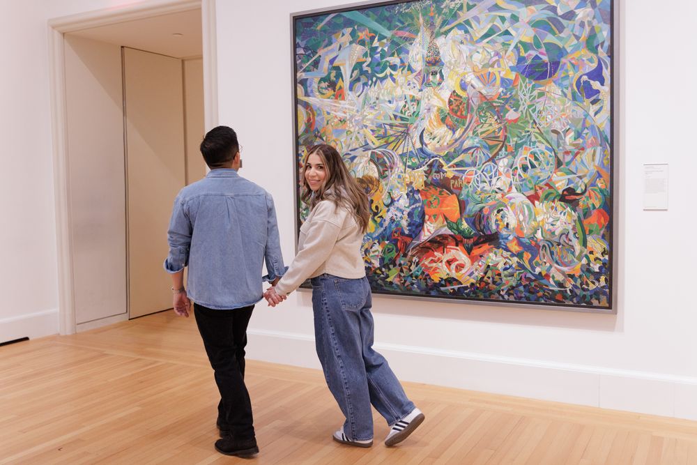 A couple walking by a blue tone painting at the Yale University Art Gallery. An engagement session at the museum.