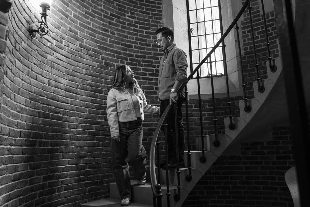 A couple standing in a brick walled stairwell at the Yale University Art Gallery. An engagement session at the museum.