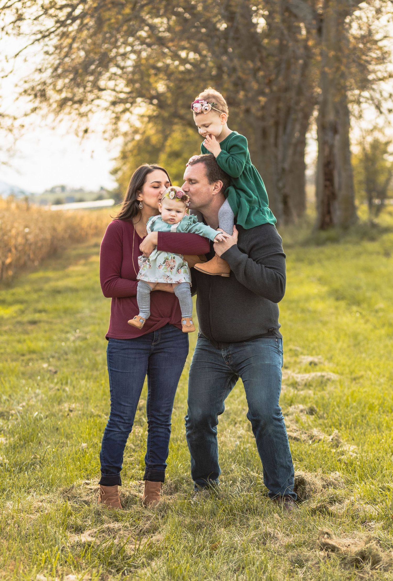 Charlottesville photographer, family, maternity, newborn, baby, mom and dad and two girls kissing and hugging in fall