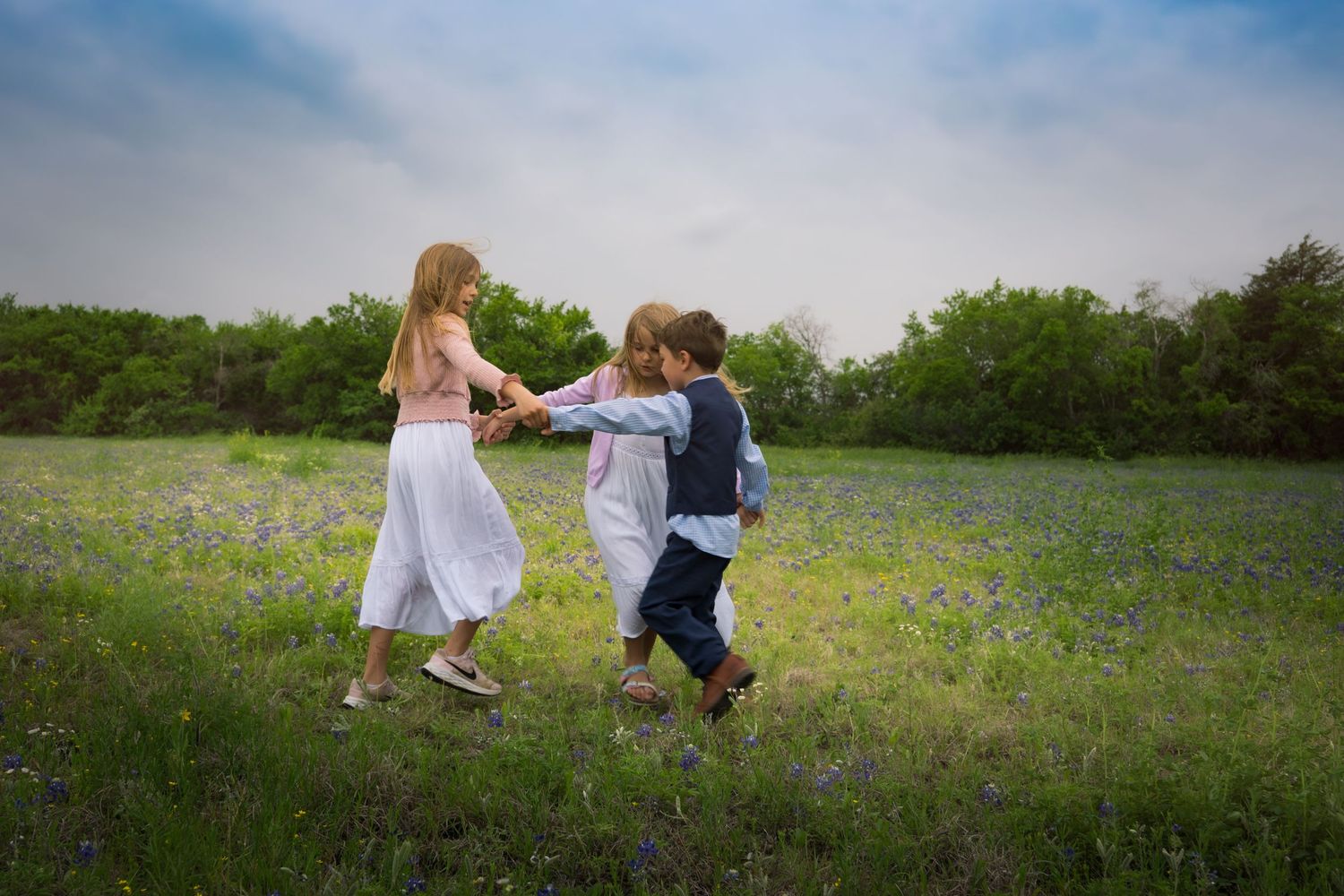 bluebonnet mini session Grapevine Texas family posed outdoors golden hour outfits playing games ring around the roses