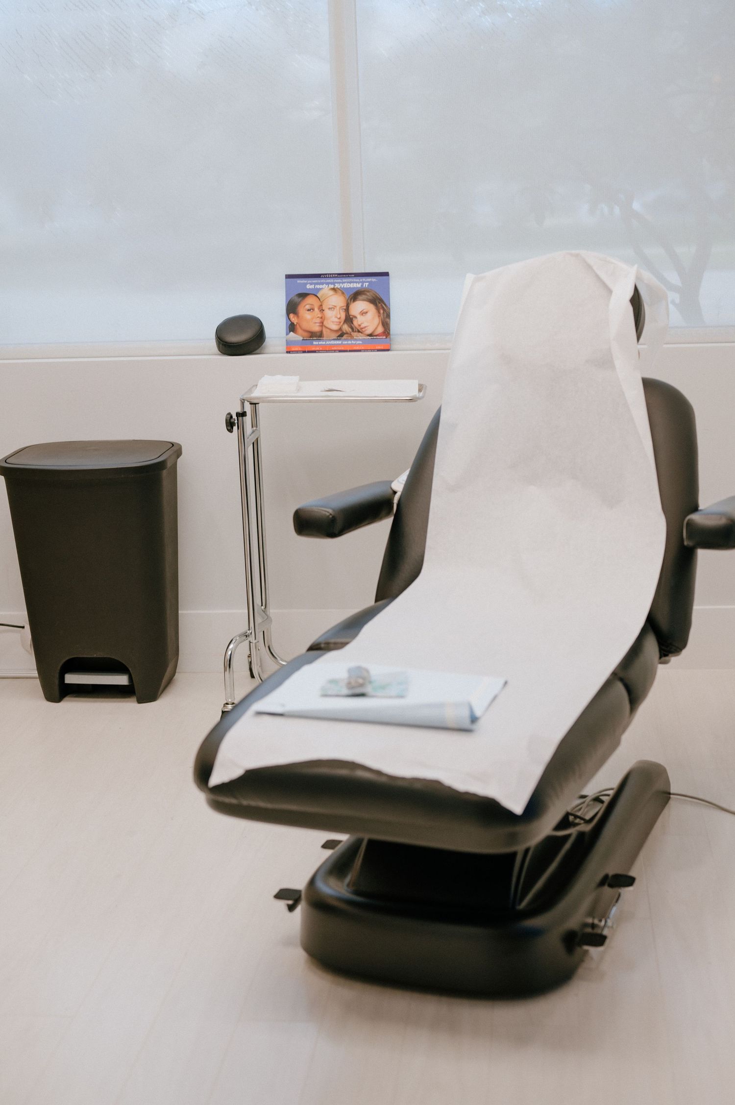 Medical treatment chair in white and black with adjustable settings in a clinical setting.