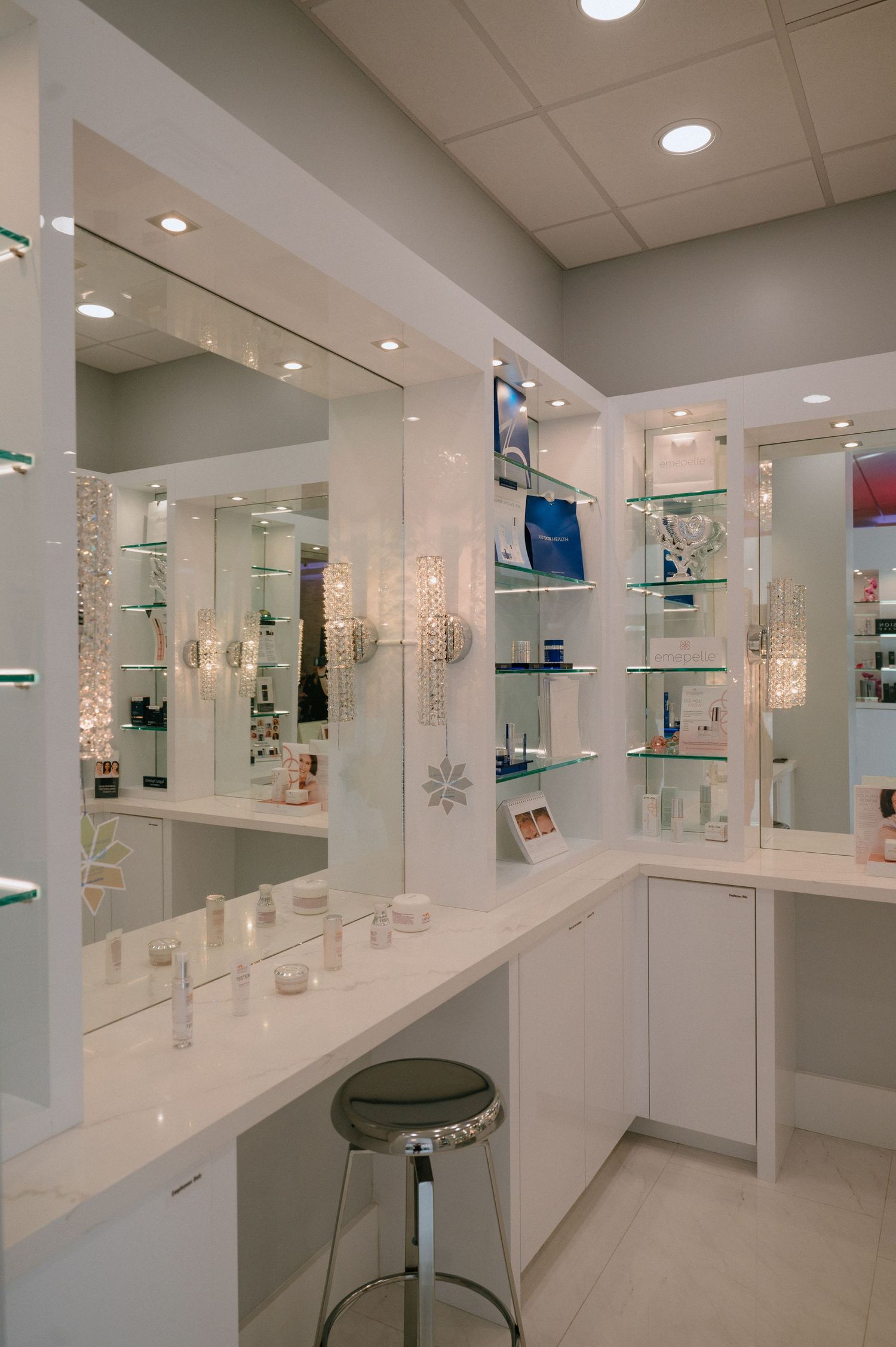 Sleek medical spa interior with illuminated glass shelving displaying beauty and skincare products.