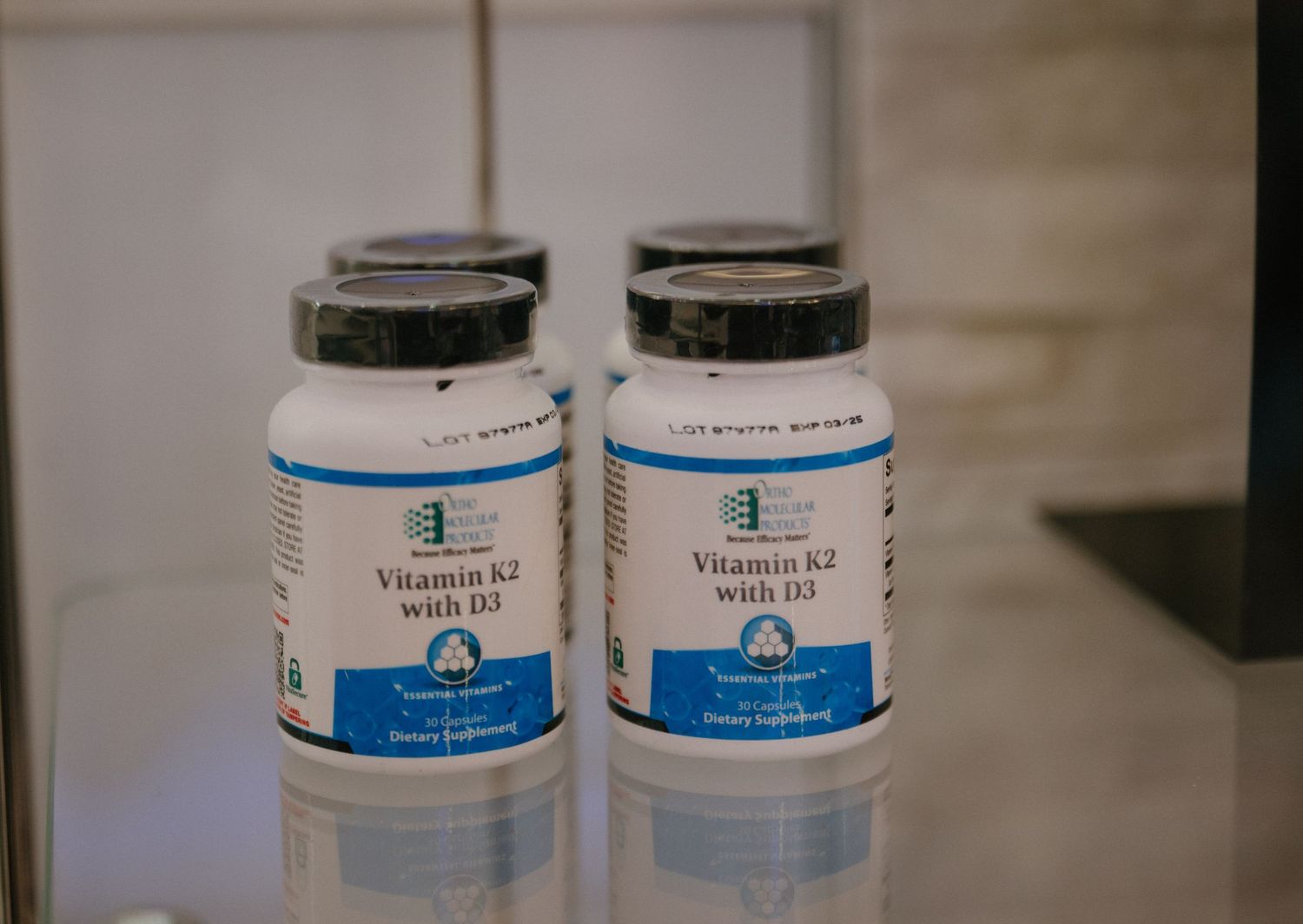 Two medical-grade vitamin supplement bottles with blue and white labels.