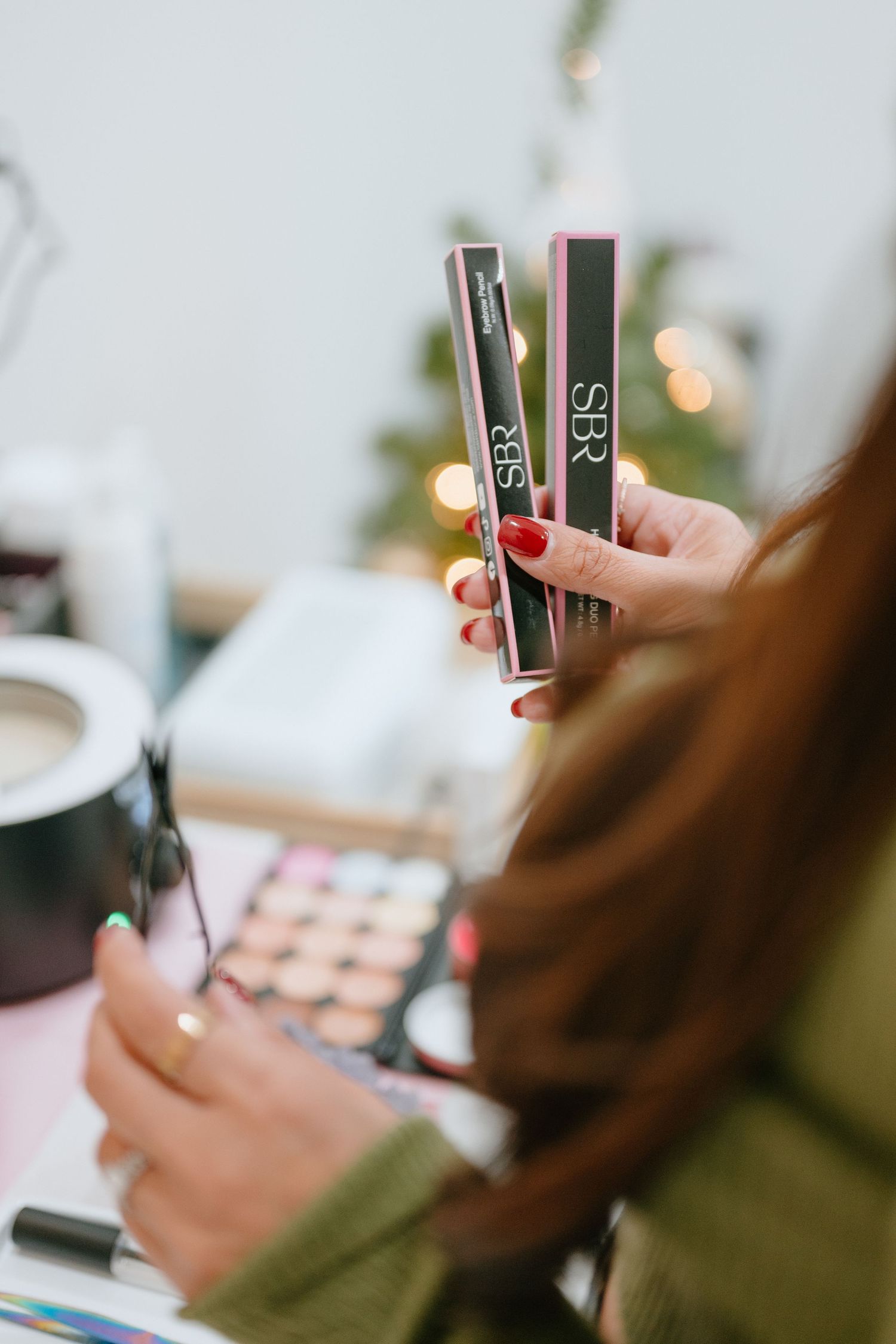 Someone holding cosmetic products with SFR branding against a blurred background.