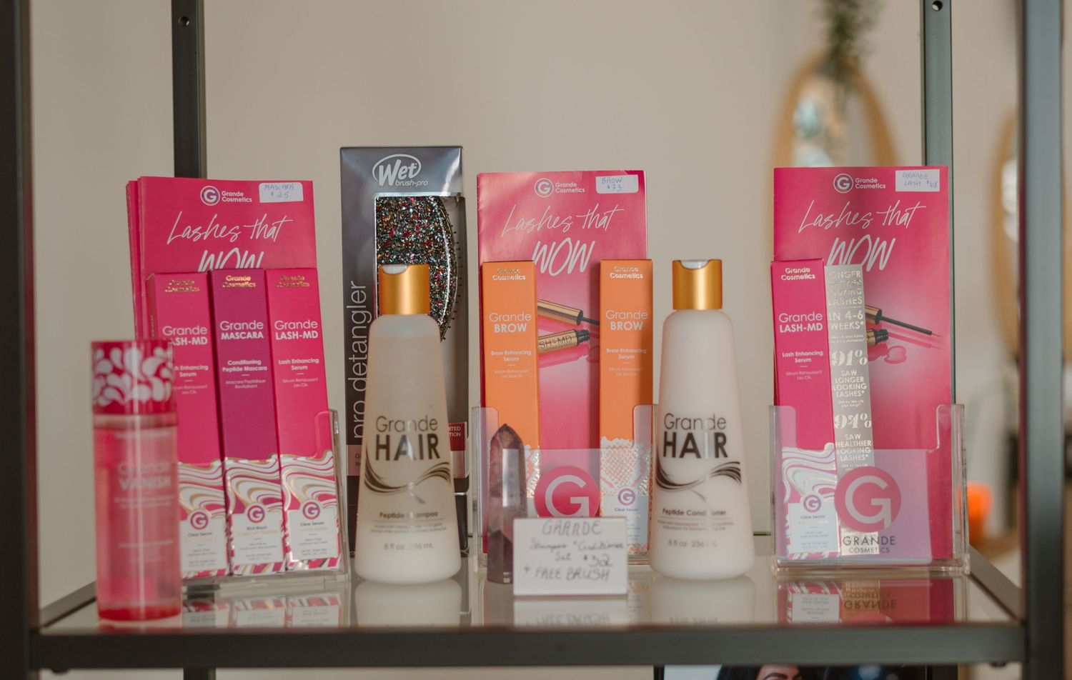 Pink and peach colored beauty product packaging displayed on retail shelf.