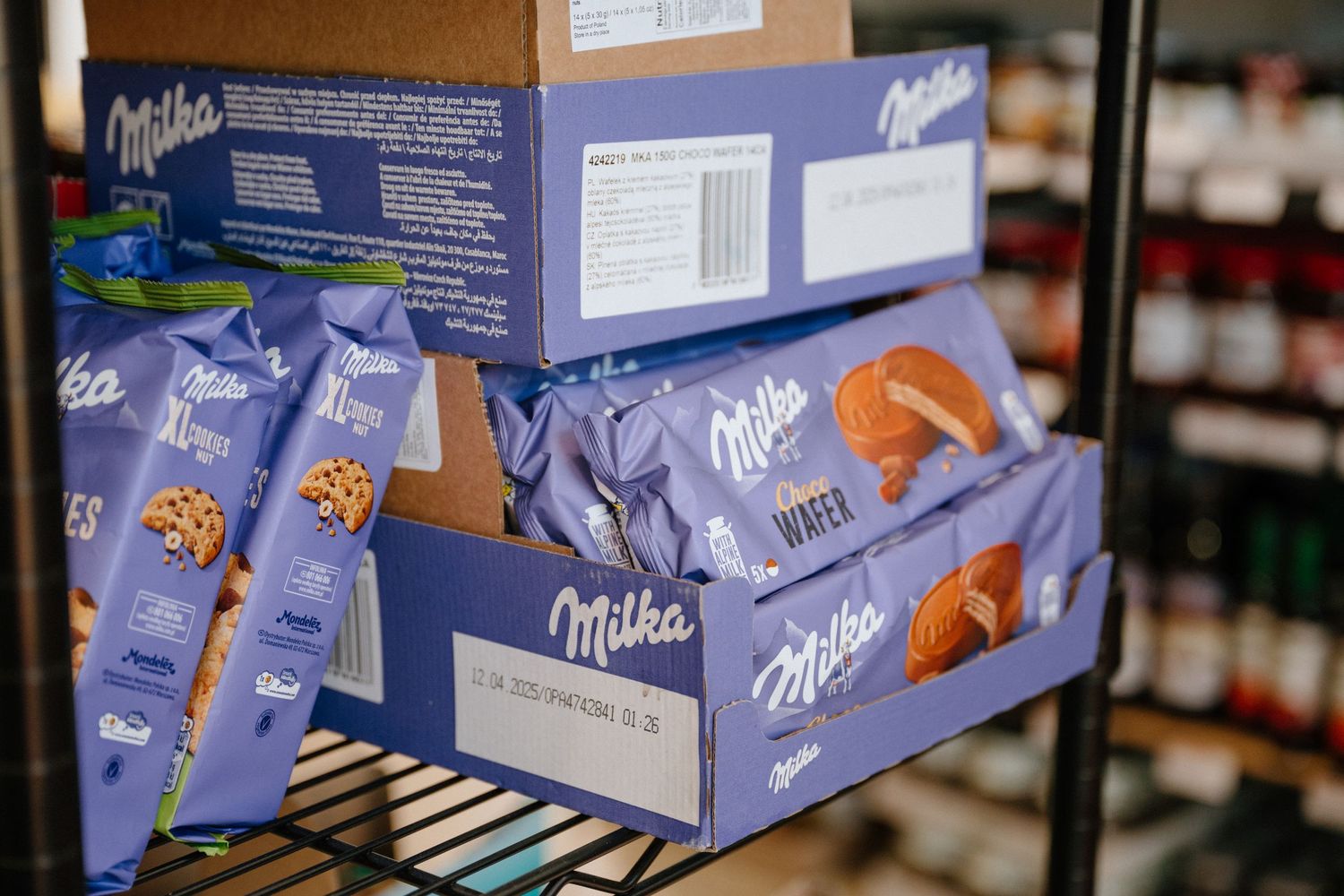 Display shelf filled with Milka chocolate bars and confectionery products.