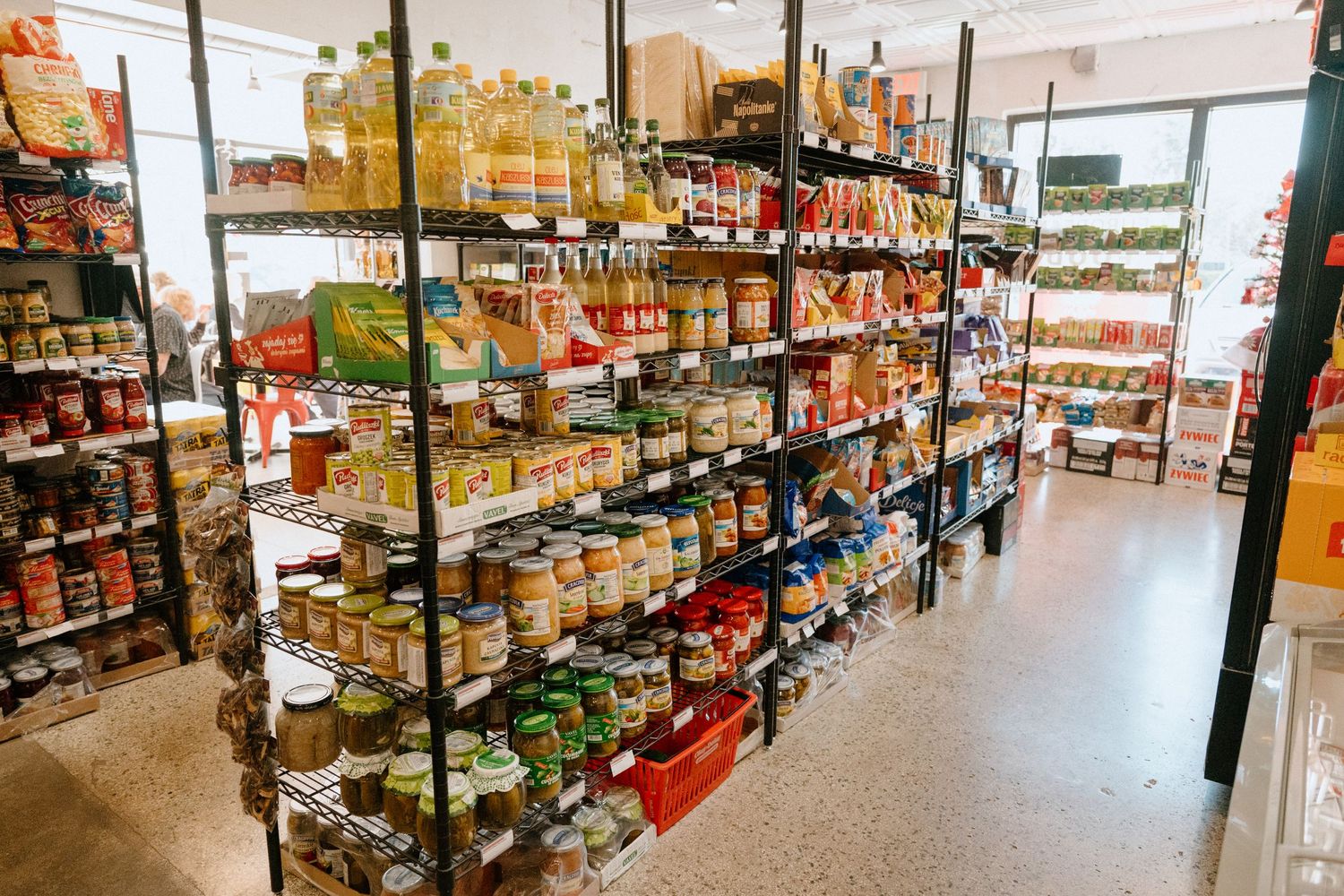 Shelves stocked with various food products and groceries in a store aisle.