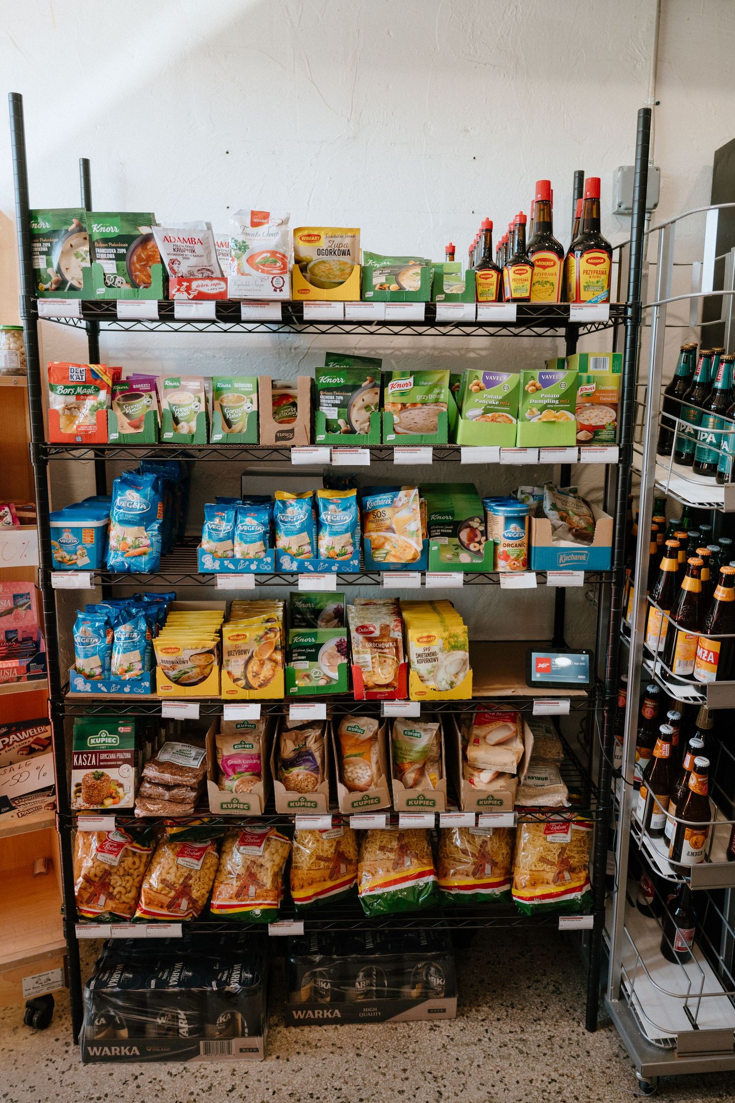 Retail shelving unit filled with organized snack foods and beverage bottles.