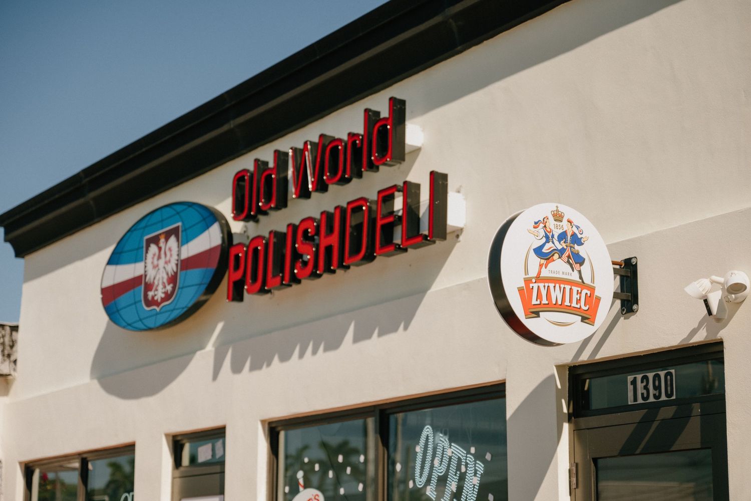 Exterior storefront sign of The Local Butcher shop against blue sky.