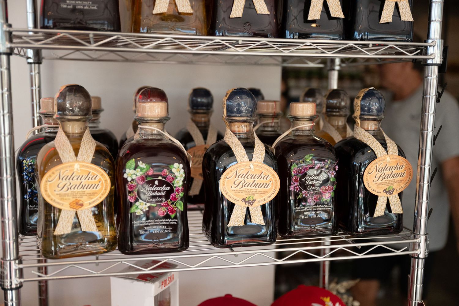 Decorative bottles of liquor displayed on metal wire shelving.