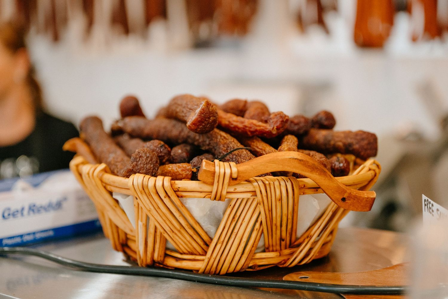 Brown nuts or chocolate pieces displayed in a woven basket.