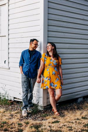 Couple in casual attire standing next to white building wall in a collage-style photo series.
