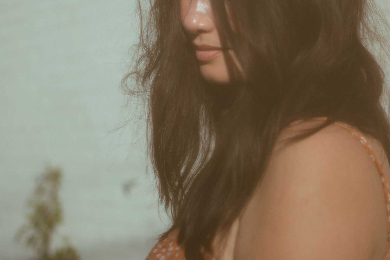 close up of woman with brown hair and orange dress