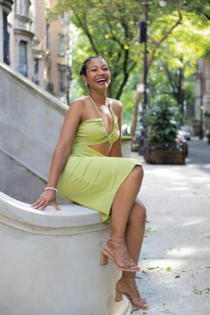 A cheerful street style photo featuring a lime green cutout dress and strappy sandals.