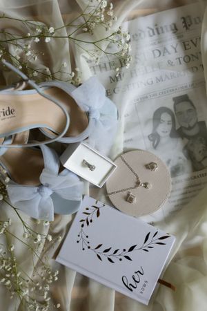 Wedding details flatlay with bridal shoes, invitation and delicate baby's breath flowers.